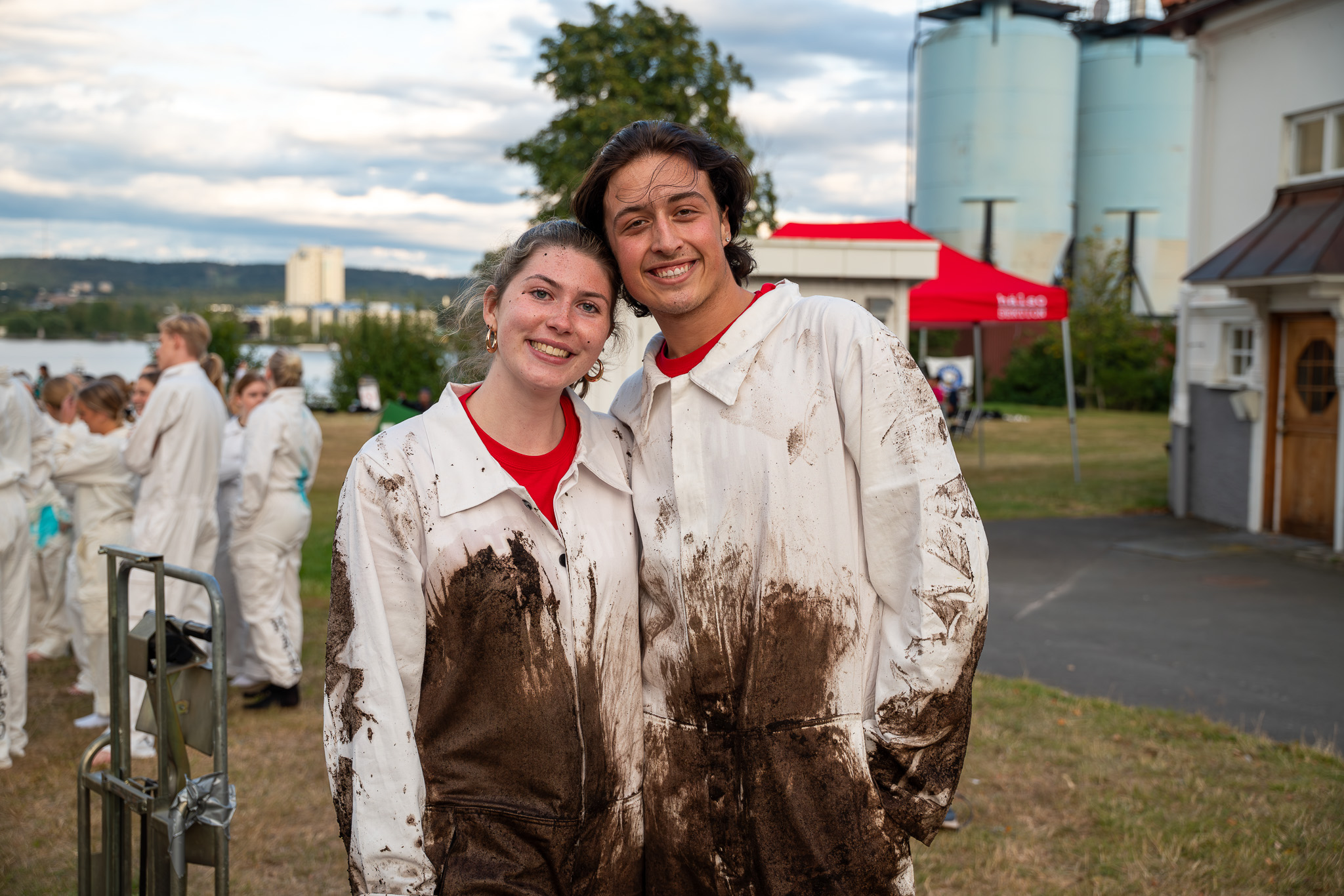Två studenter på insparken i sina vita overaller som ler och tittar in i kameran