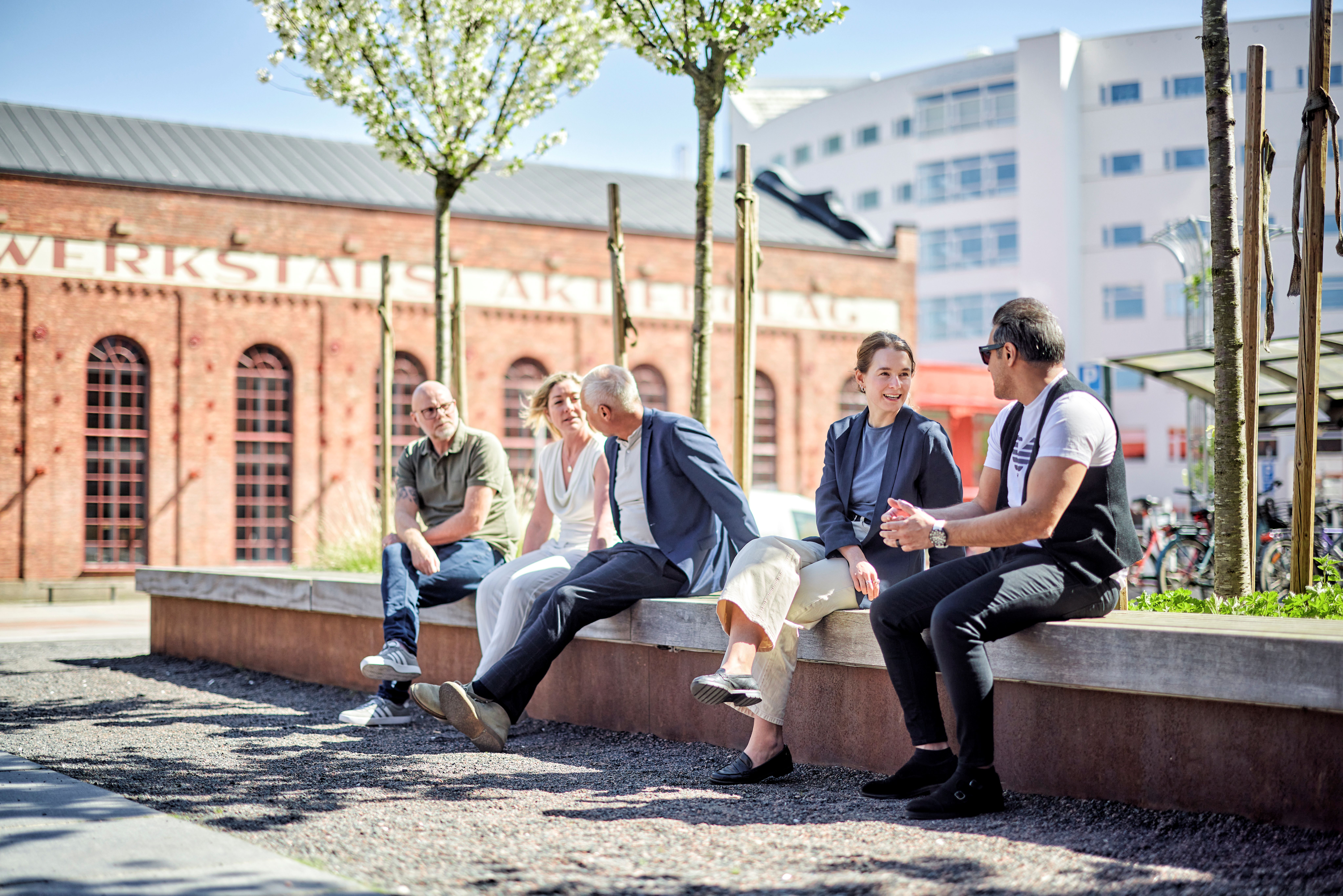 En grupp personer sitter ute i solen